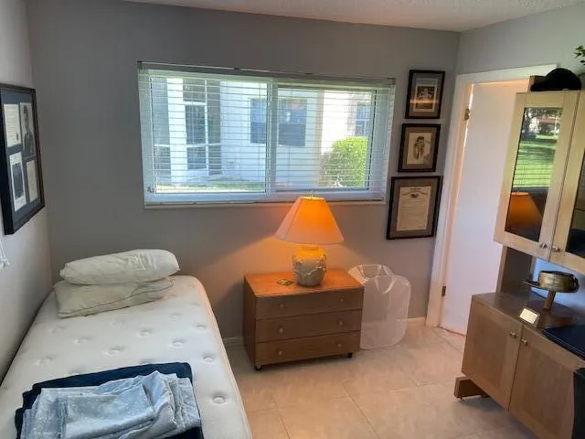 Ceramic tile flooring, neutral wall tones, single window with blinds, recessed lighting, and a built-in cabinetry unit