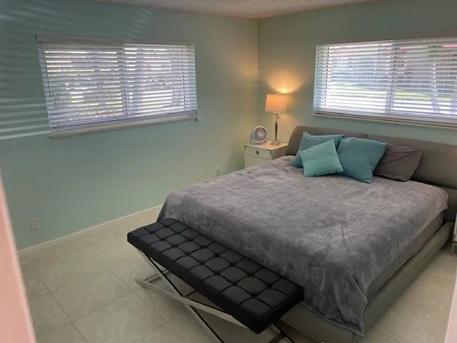 Dual windows with blinds, recessed lighting, and light-toned tile flooring