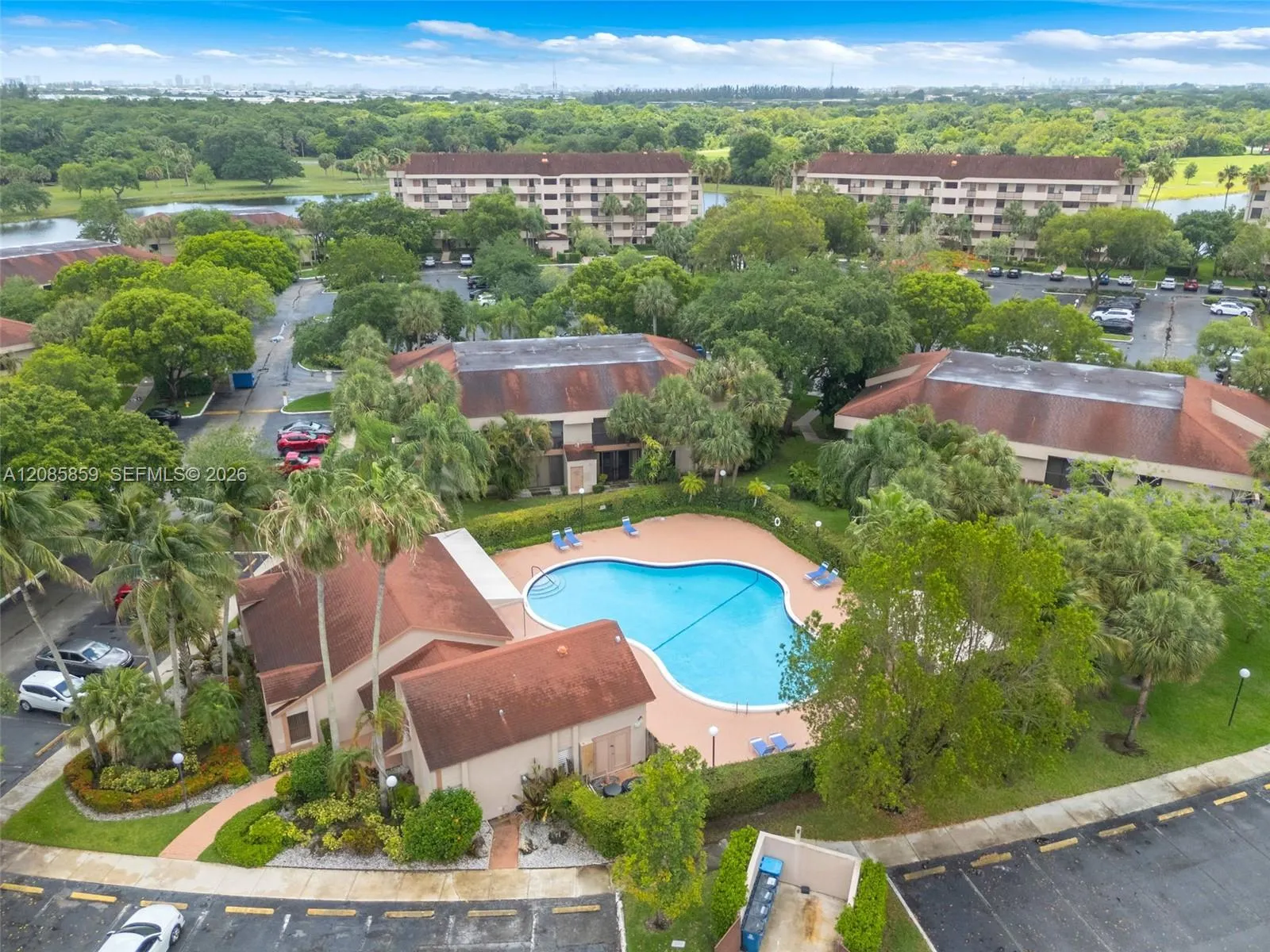 Beautiful aerial view of the community, pool area, surrounding greenery, and waterways.