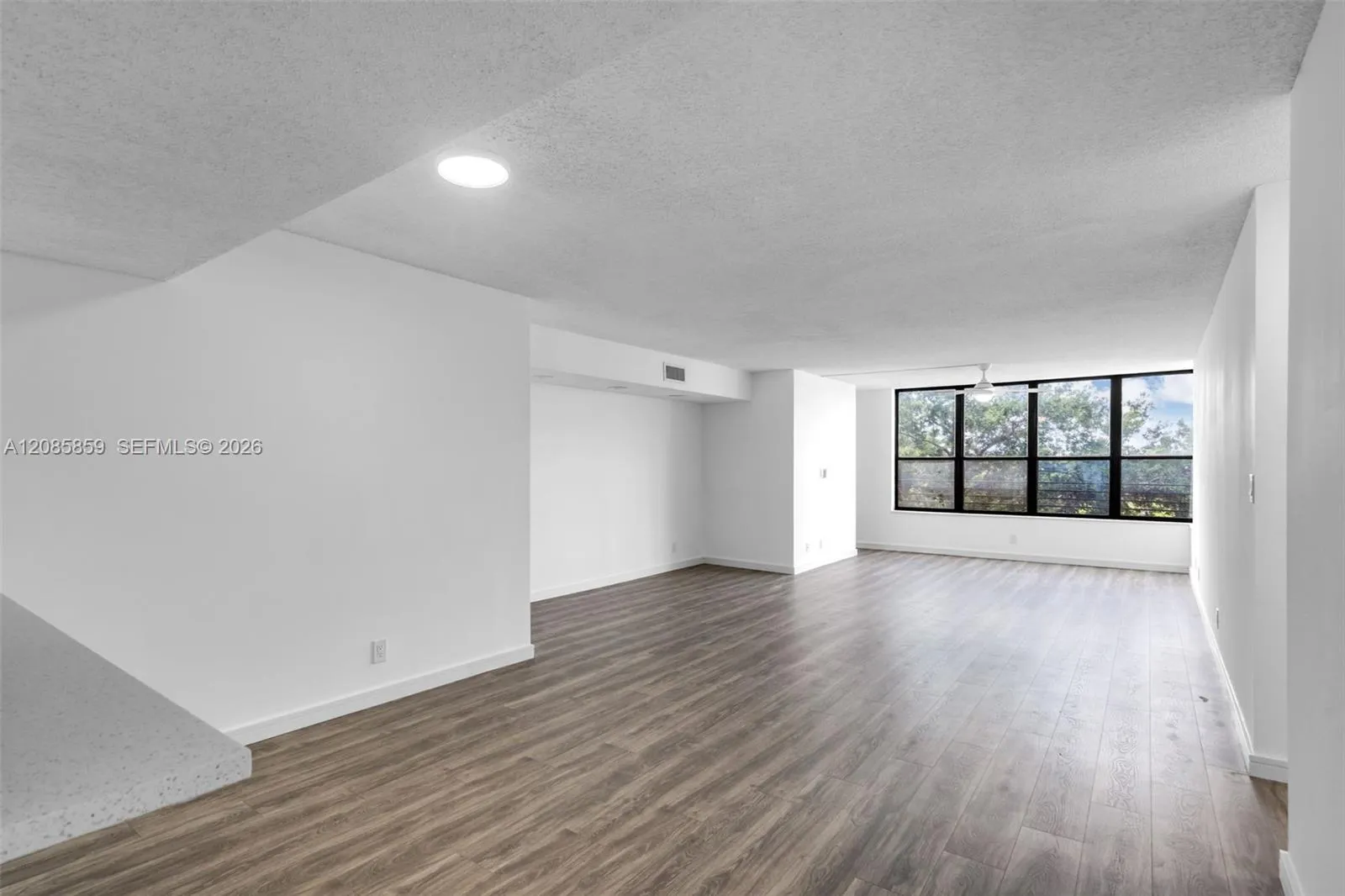 Unfurnished view of the expansive living area showcasing the seamless layout and lake-facing windows.