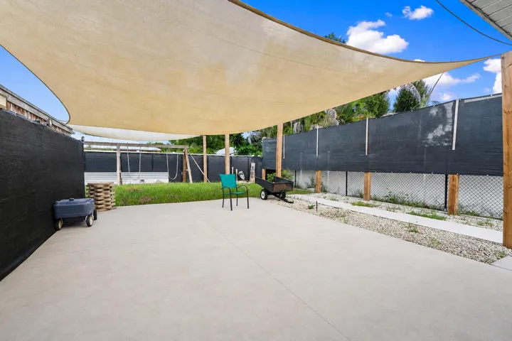 Expansive concrete patio with a large fabric shade structure