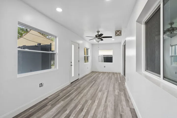Spacious room featuring wood-finish flooring, recessed lighting, and multiple windows