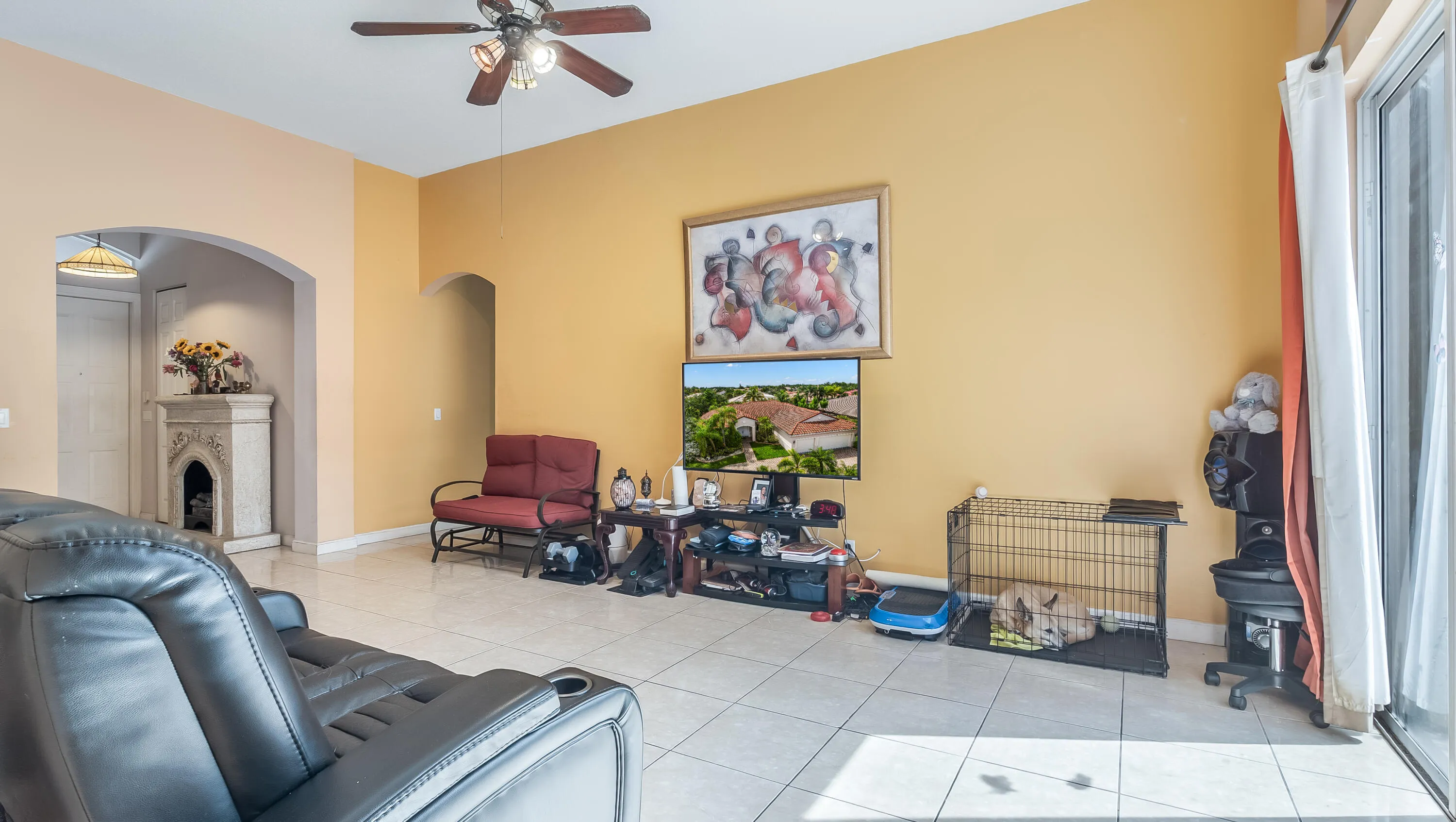 Recessed lighting, arched doorway, permanent fireplace, tile flooring, and ceiling fan