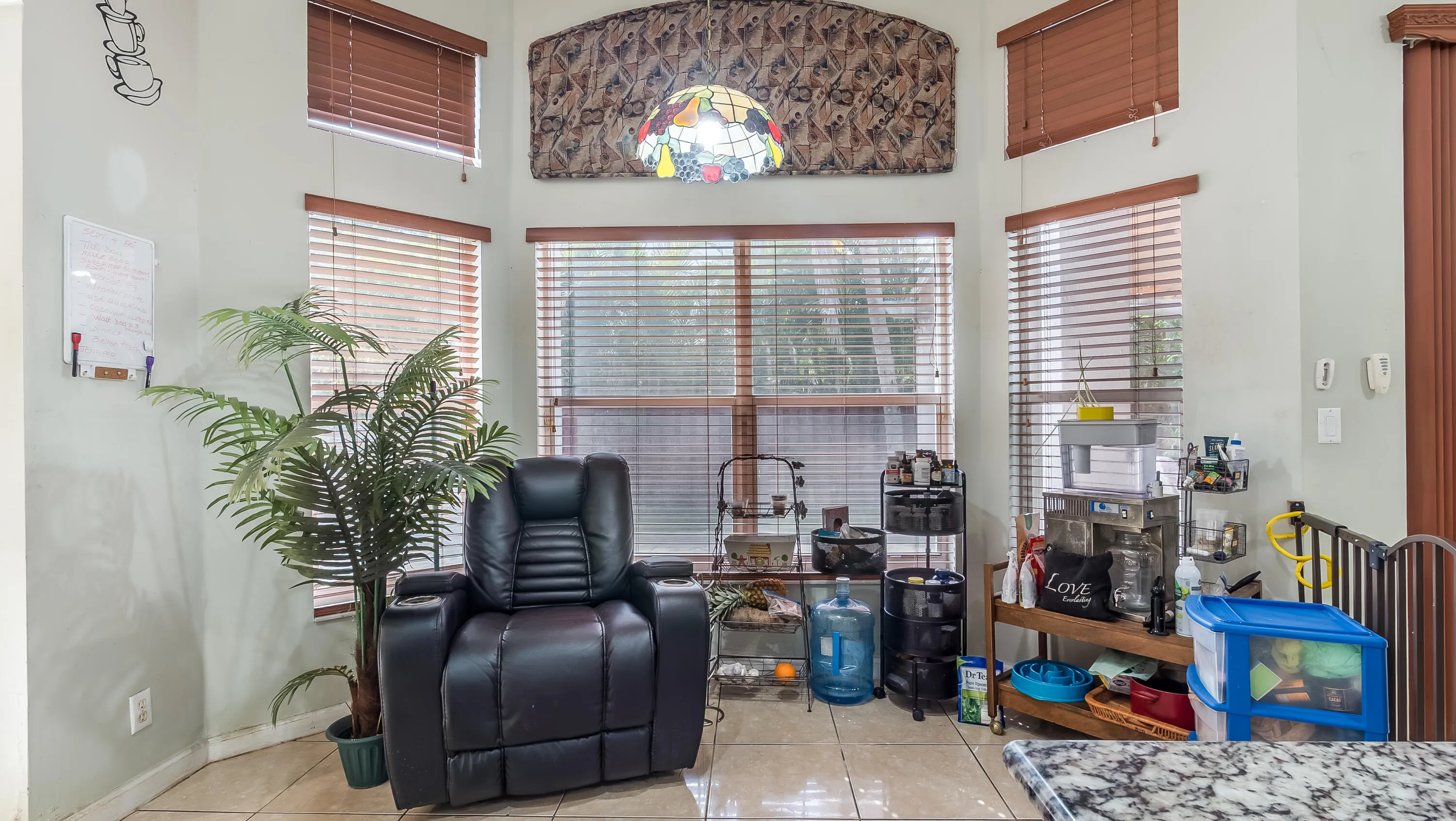 Recessed bay window with multiple windows, tile flooring, and a decorative stained glass light fixture