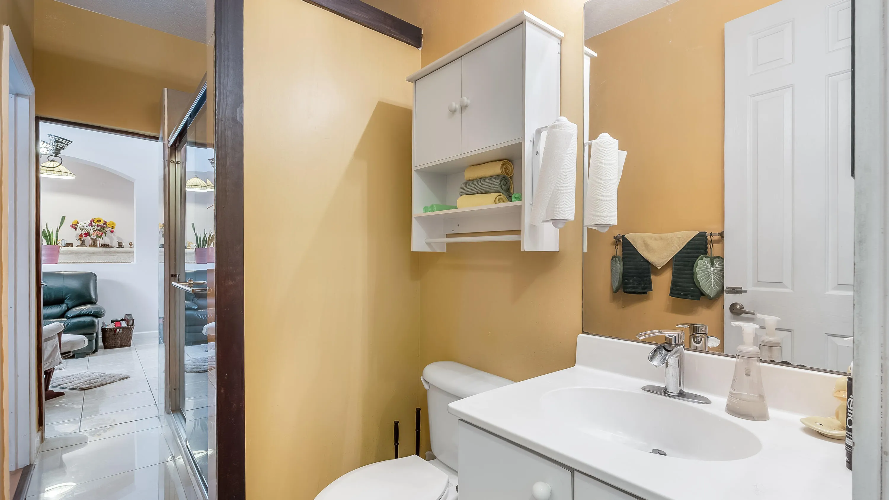 Vanity with an integrated sink, built-in wall cabinet, and a white paneled door