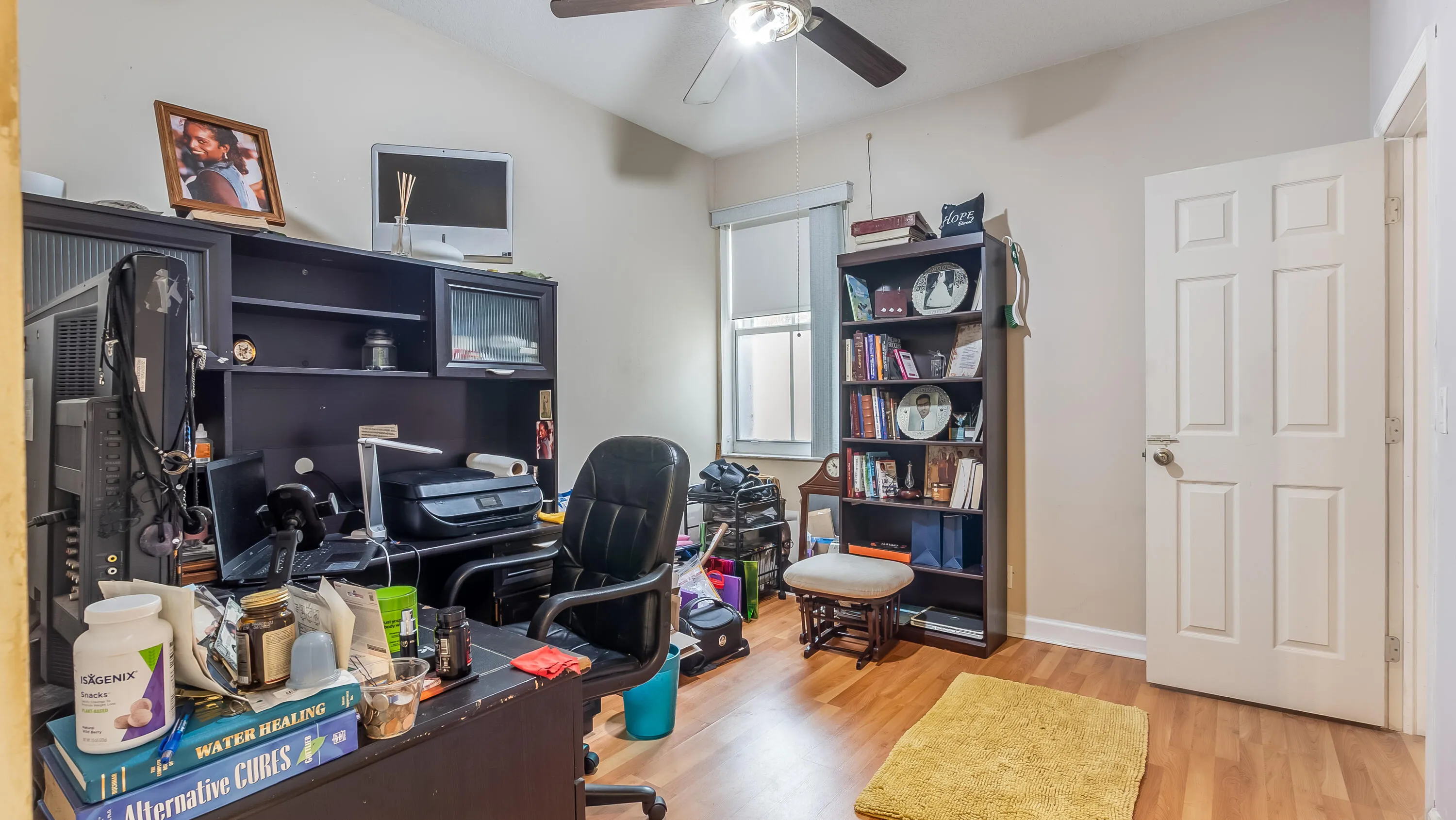 Wood-finish flooring, a ceiling fan, and painted walls