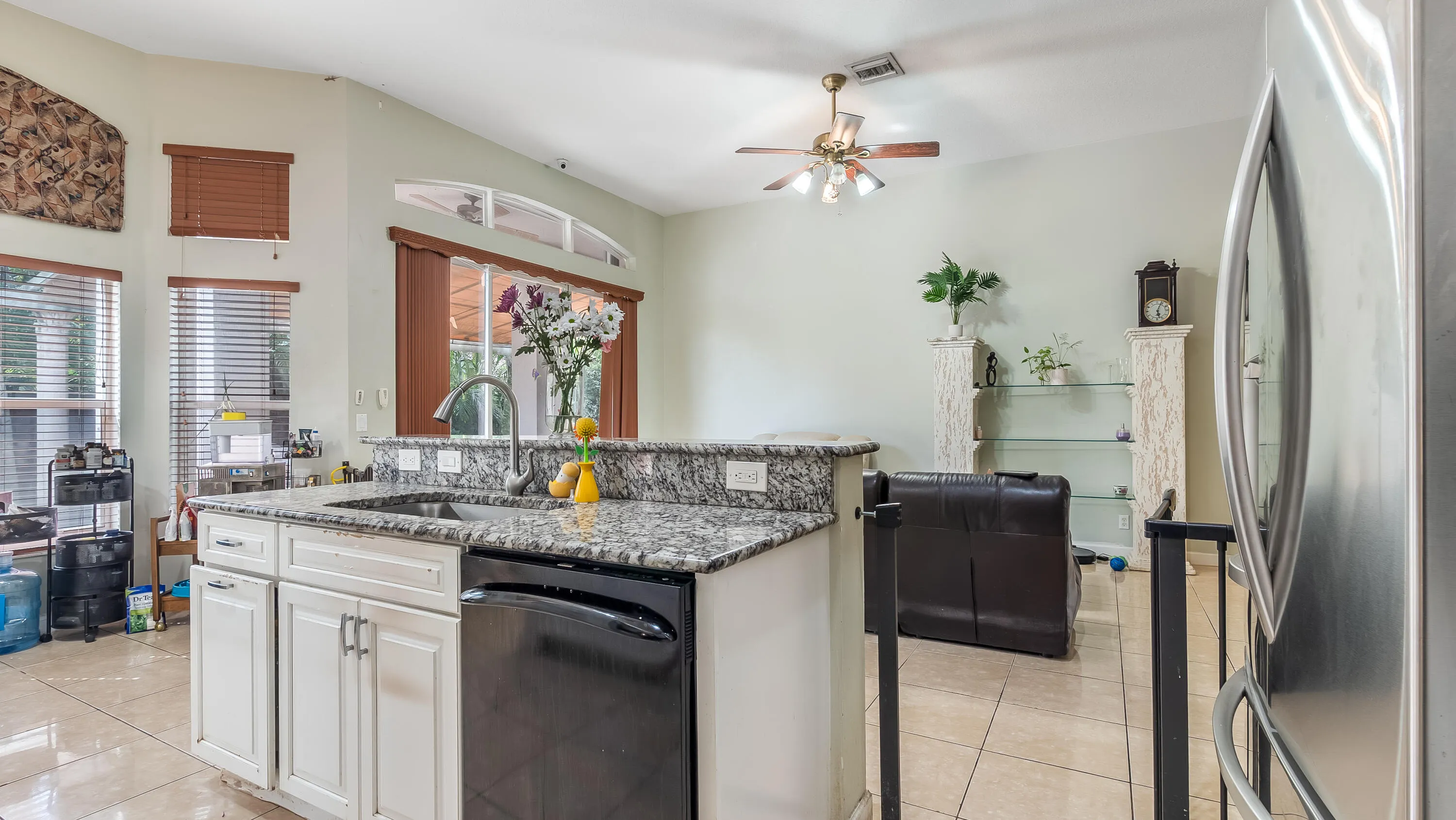 Kitchen island with a granite countertop, undermount sink, and integrated dishwasher