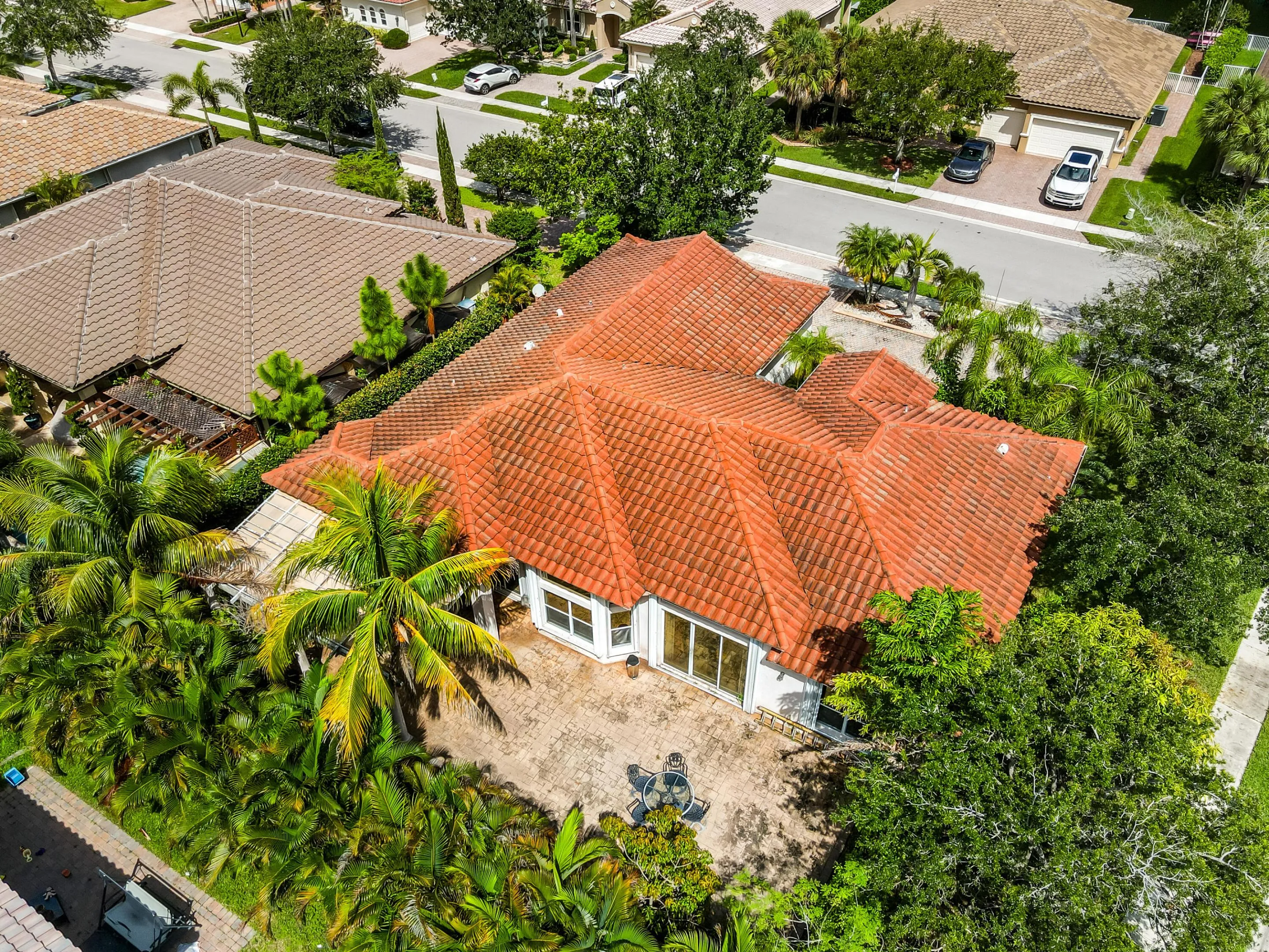 Terra cotta tile roof, ample patio area, and mature landscaping
