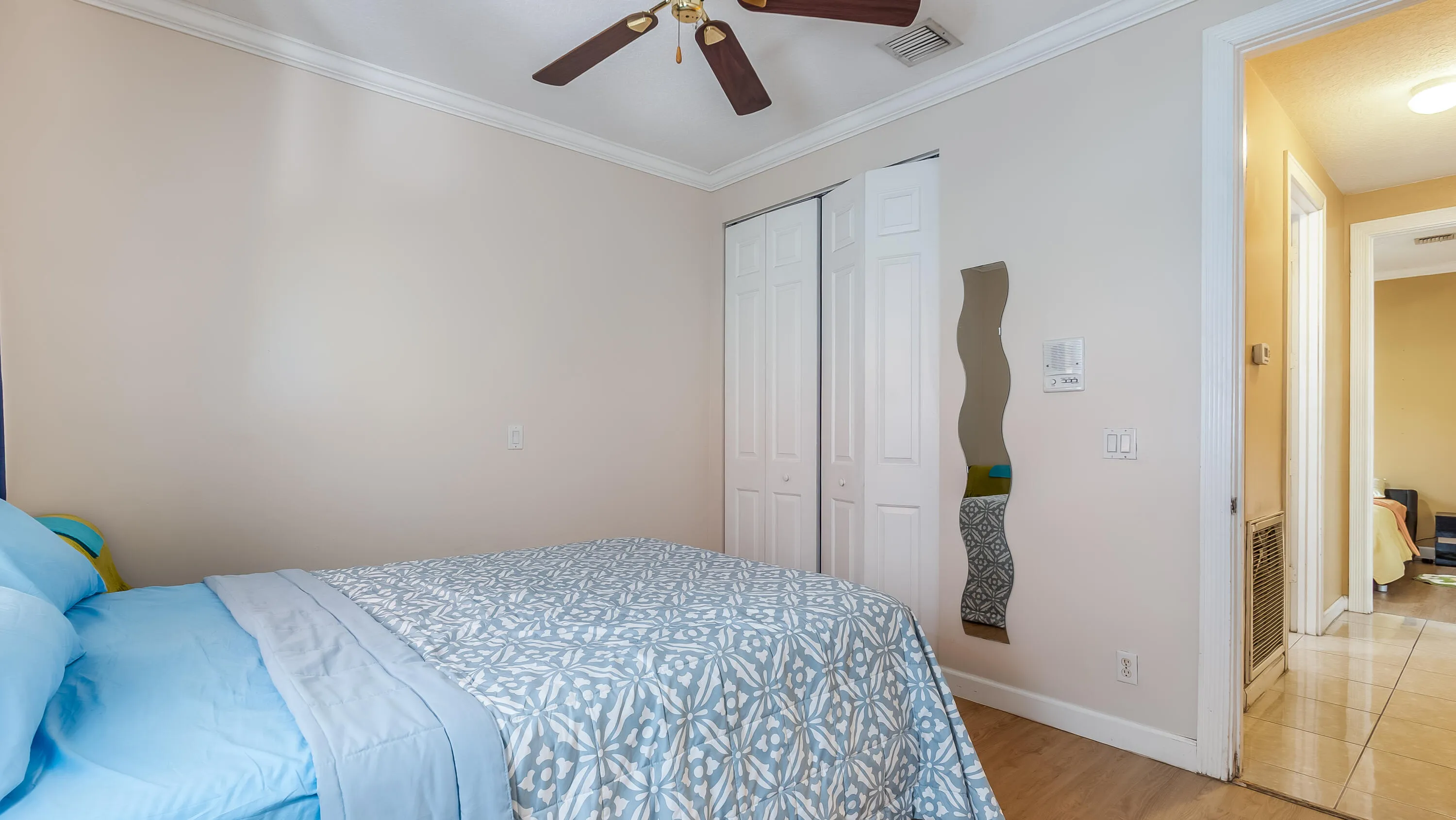 Wood-finish flooring, crown molding, ceiling fan, bi-fold closet doors