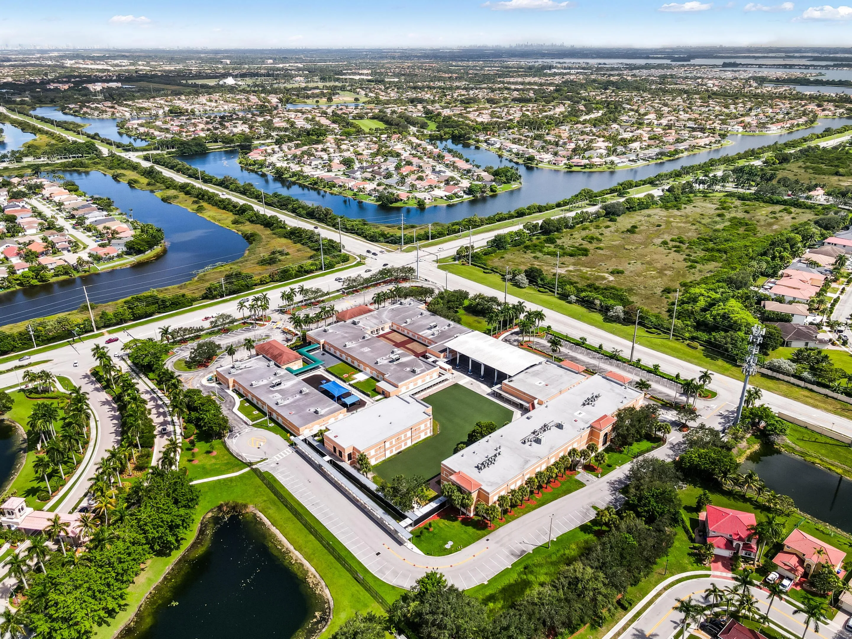 Aerial perspective showcasing a structured building complex, surrounding residential areas, and expansive waterways
