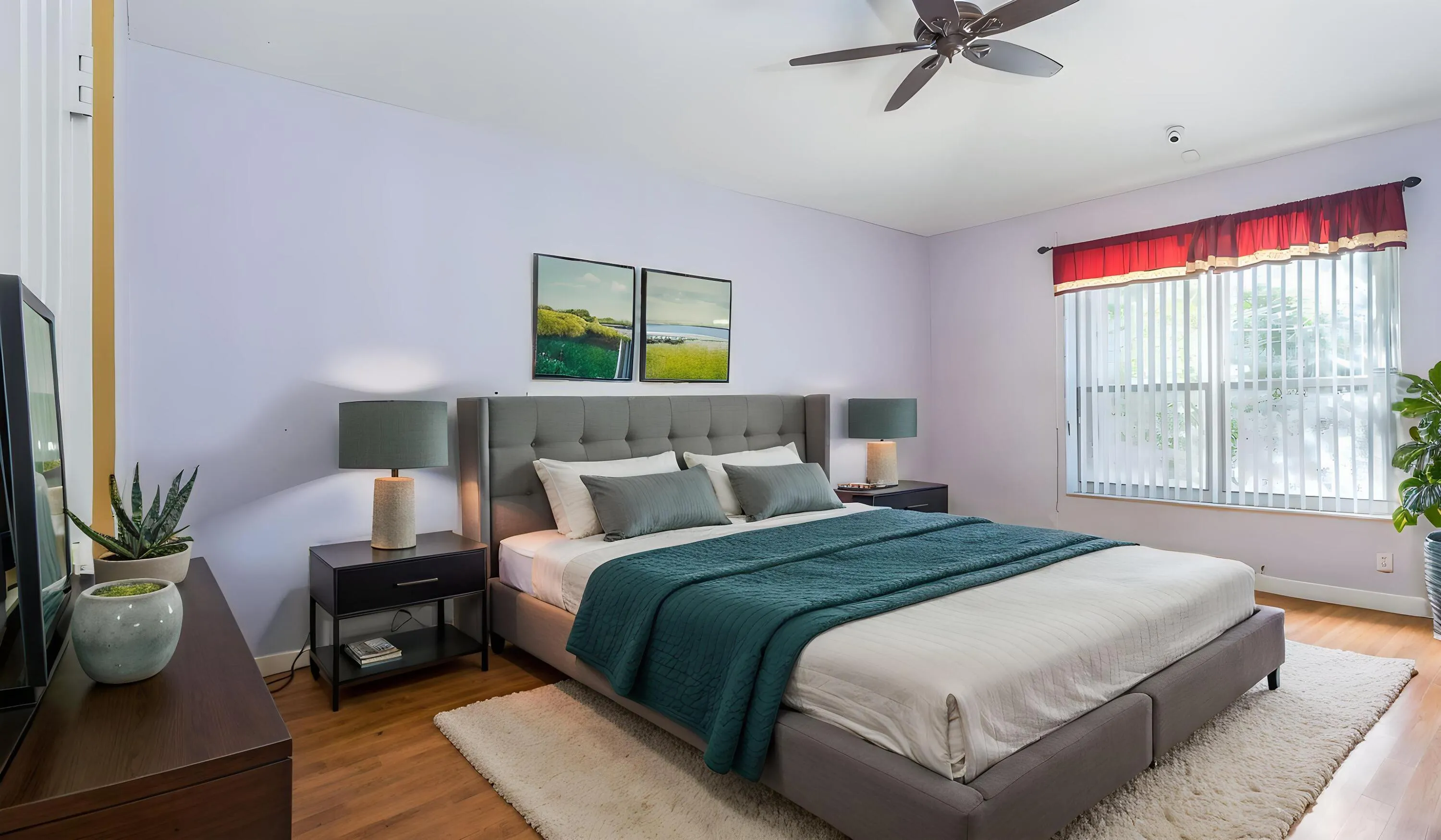 Wood-finish flooring, ceiling fan, large window with vertical blinds, and a built-in wall niche