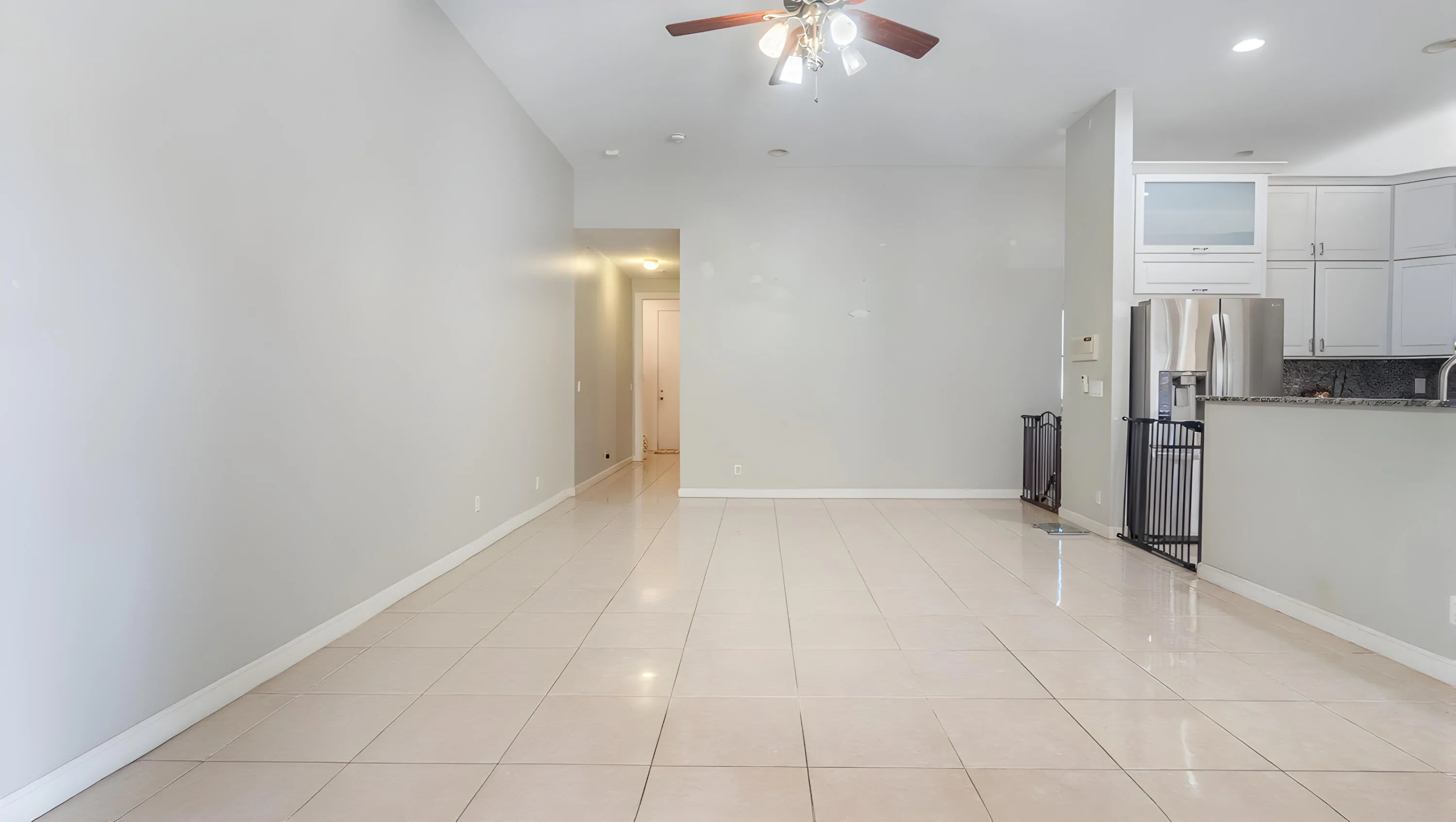 Open-concept living area with tile flooring and a ceiling fan