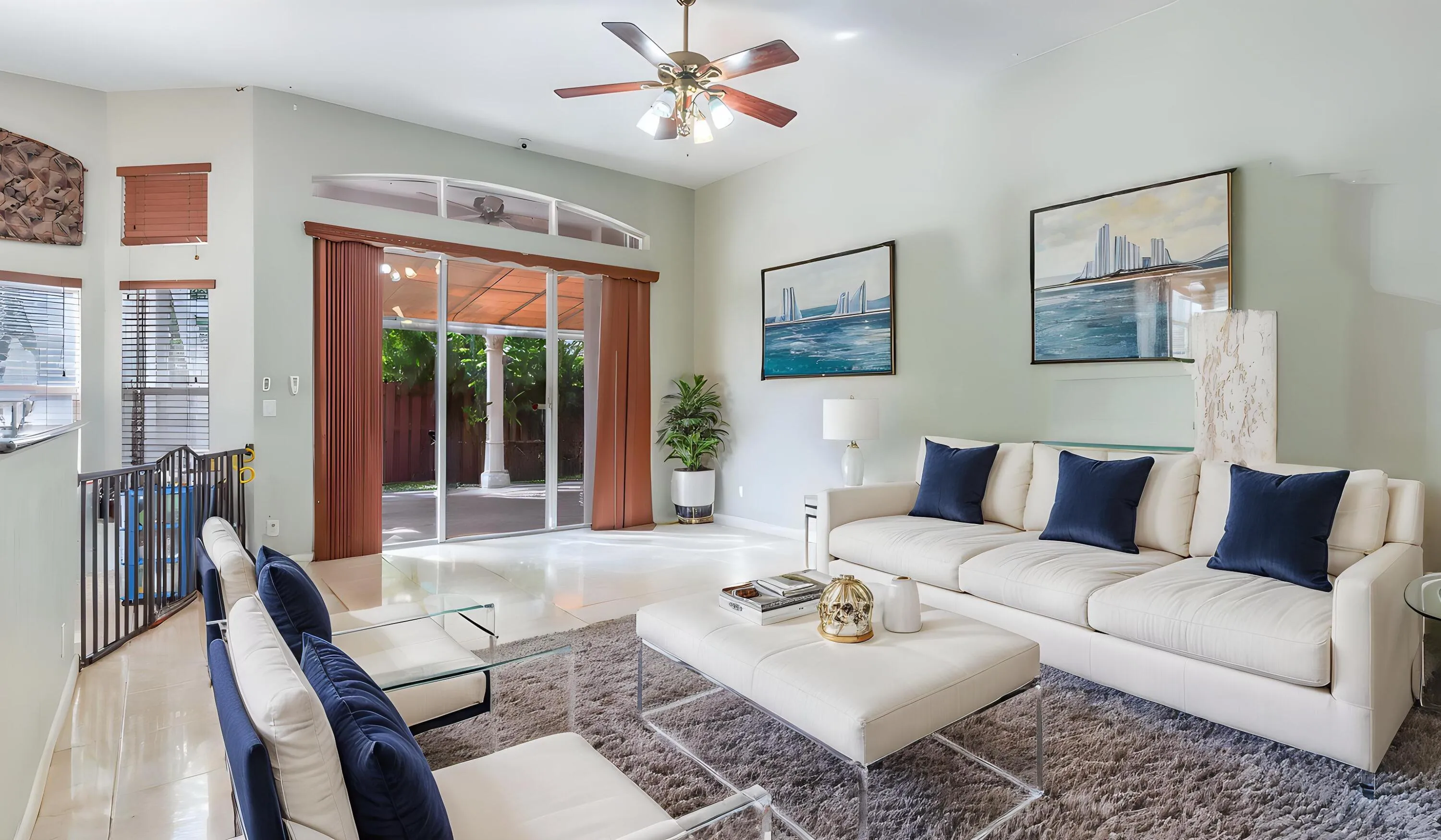 Vaulted ceilings with a ceiling fan, sliding glass doors, and light-tone tile flooring