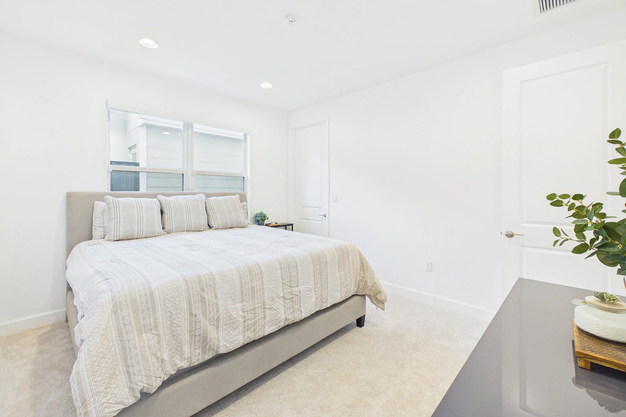 Recessed ceiling lighting, white walls, carpeted flooring, and white trim