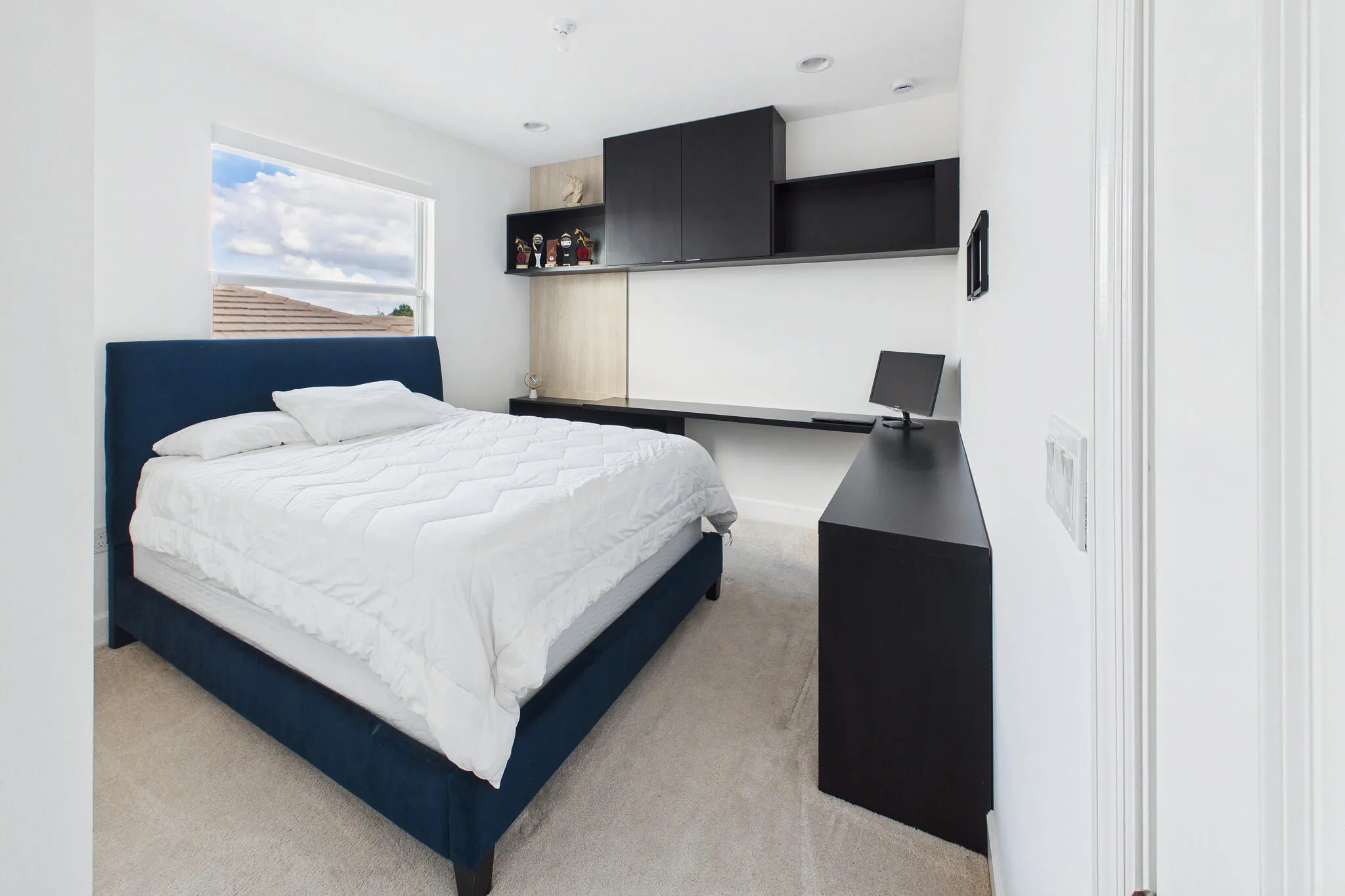 Recessed lighting, wall-mounted cabinetry, built-in desk, and carpeted flooring