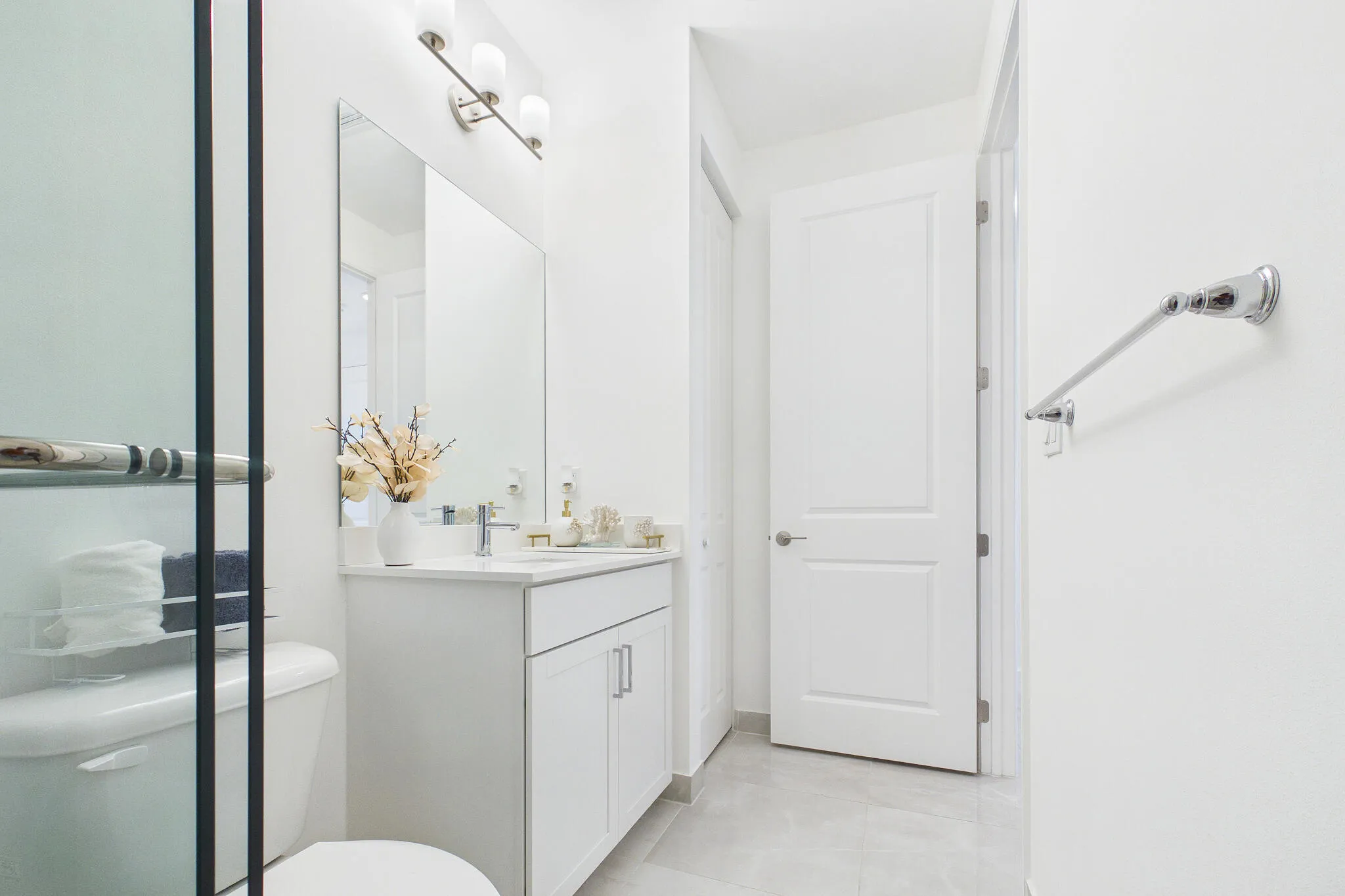 White vanity with chrome hardware, an integrated sink, and a rectangular mirror
