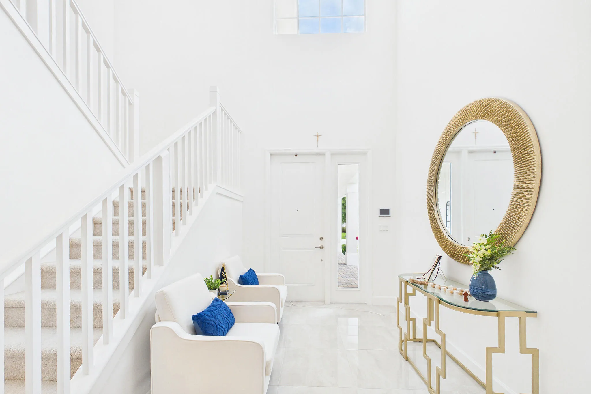 Two-story foyer featuring a transom window, double-door entry with sidelight, white baluster staircase, and tile flooring
