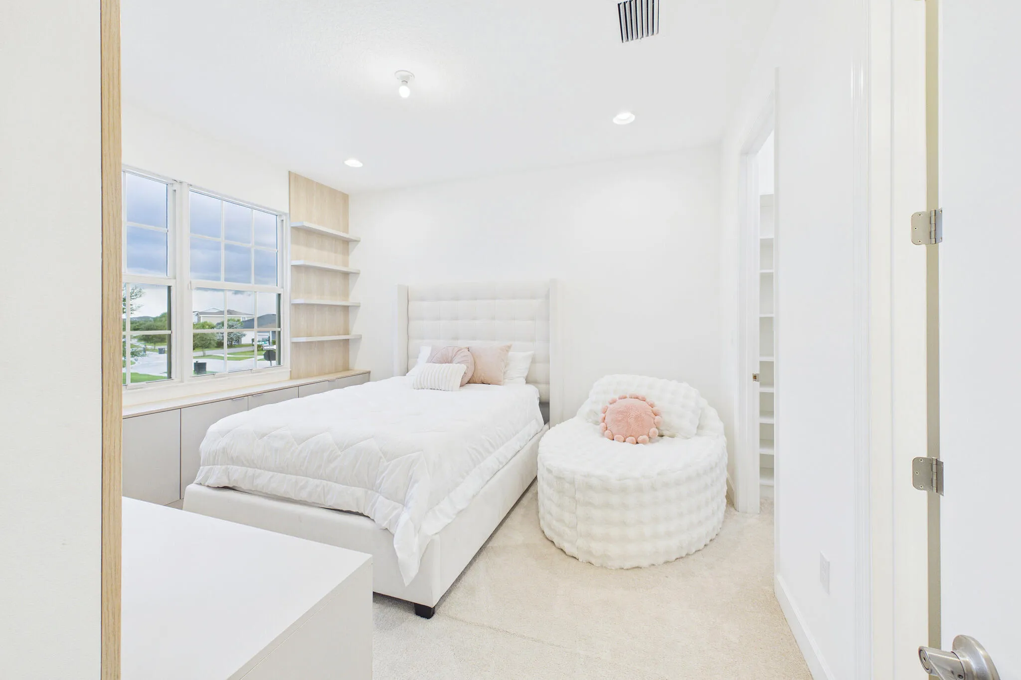 Built-in shelving and cabinetry below a large window