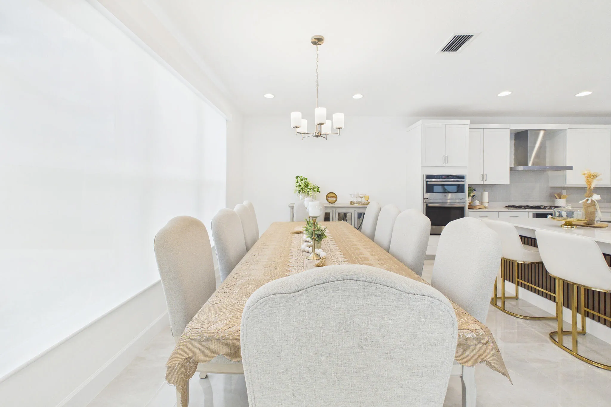 Open-concept living space with sleek tile flooring, a modern chandelier, and recessed lighting