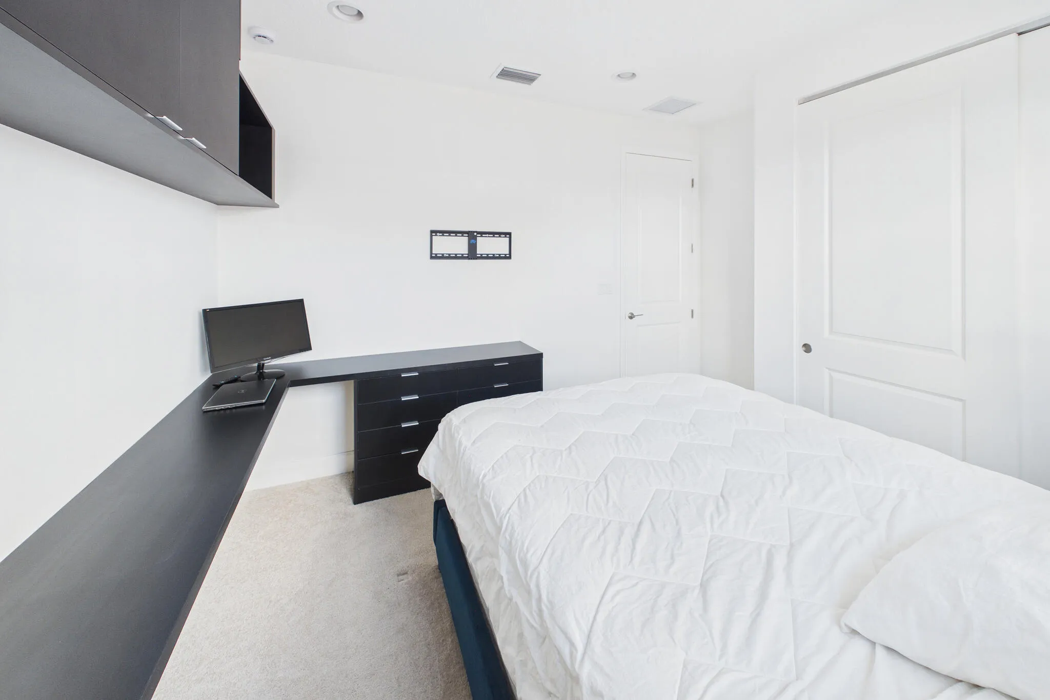 Built-in desk with extensive counter space, integrated drawers, and overhead cabinetry