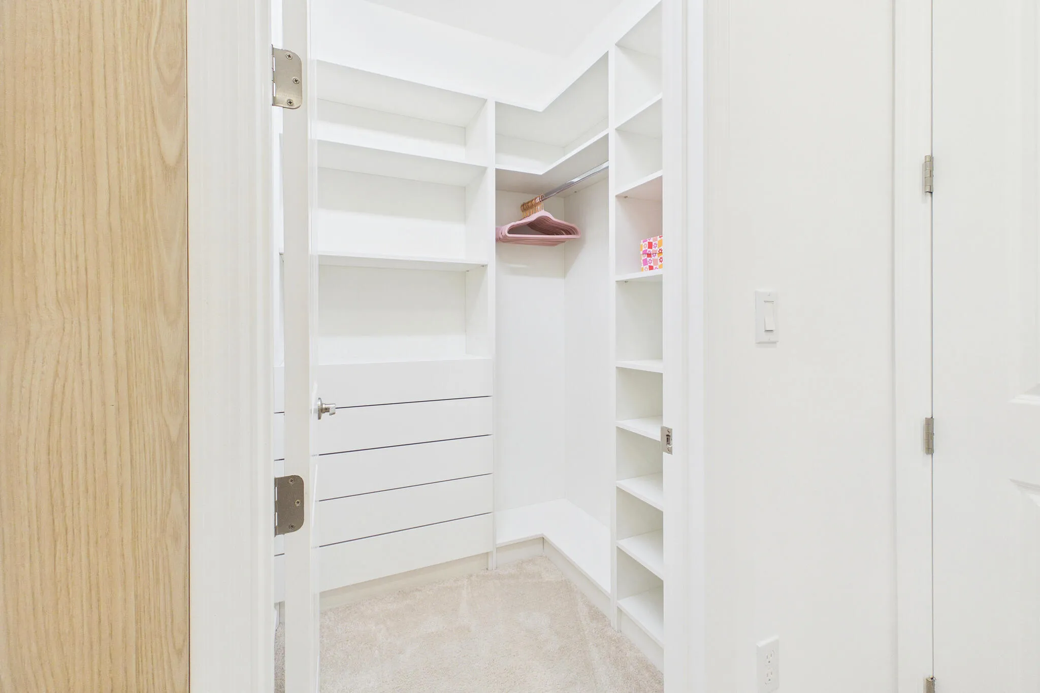 Custom closet system featuring built-in shelving, drawers, and hanging rods