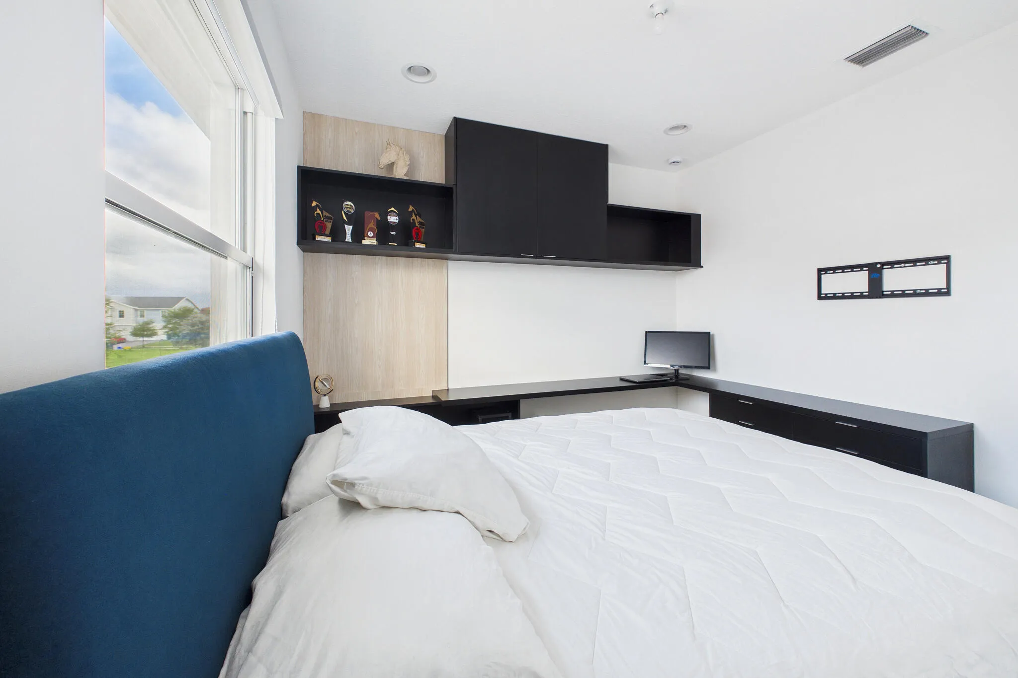 Recessed lighting, built-in shelving, expansive window, integrated desk, and dark cabinetry