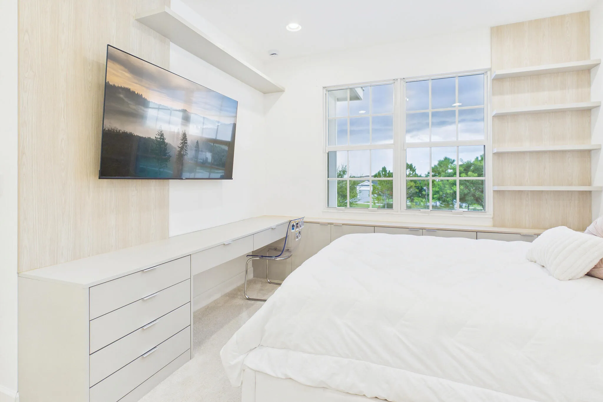 Built-in desk with integrated drawer storage, dual pane windows, built-in shelving, and light wood-finish wall accents