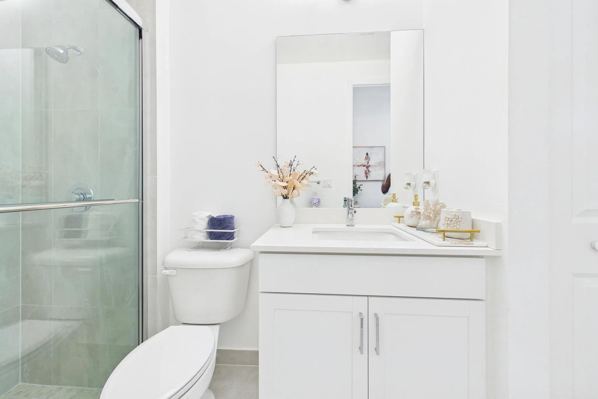White single vanity with integrated sink, chrome faucet, and mirrored medicine cabinet