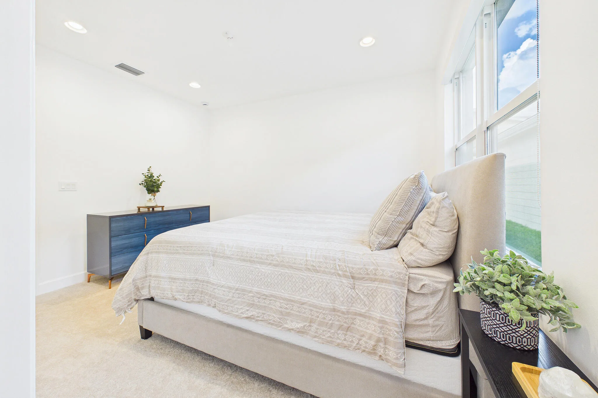 Recessed lighting illuminates a space featuring a large window