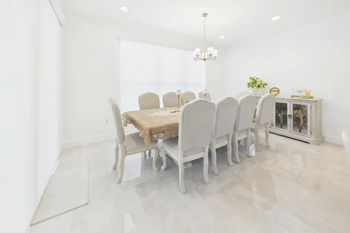 Recessed lighting, chandelier, window with roller shade, and tile flooring