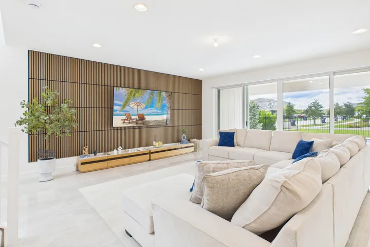 Living area featuring a slatted wood-finish accent wall, recessed lighting, and large sliding glass doors