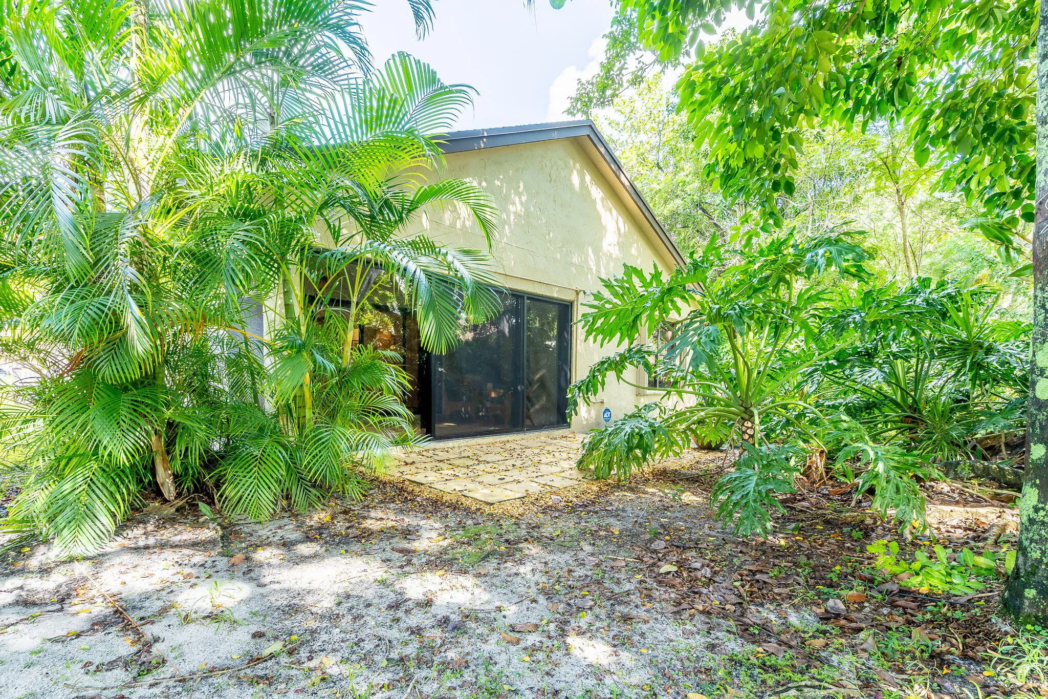 Exterior featuring stucco siding, black screened doors, and a paver patio