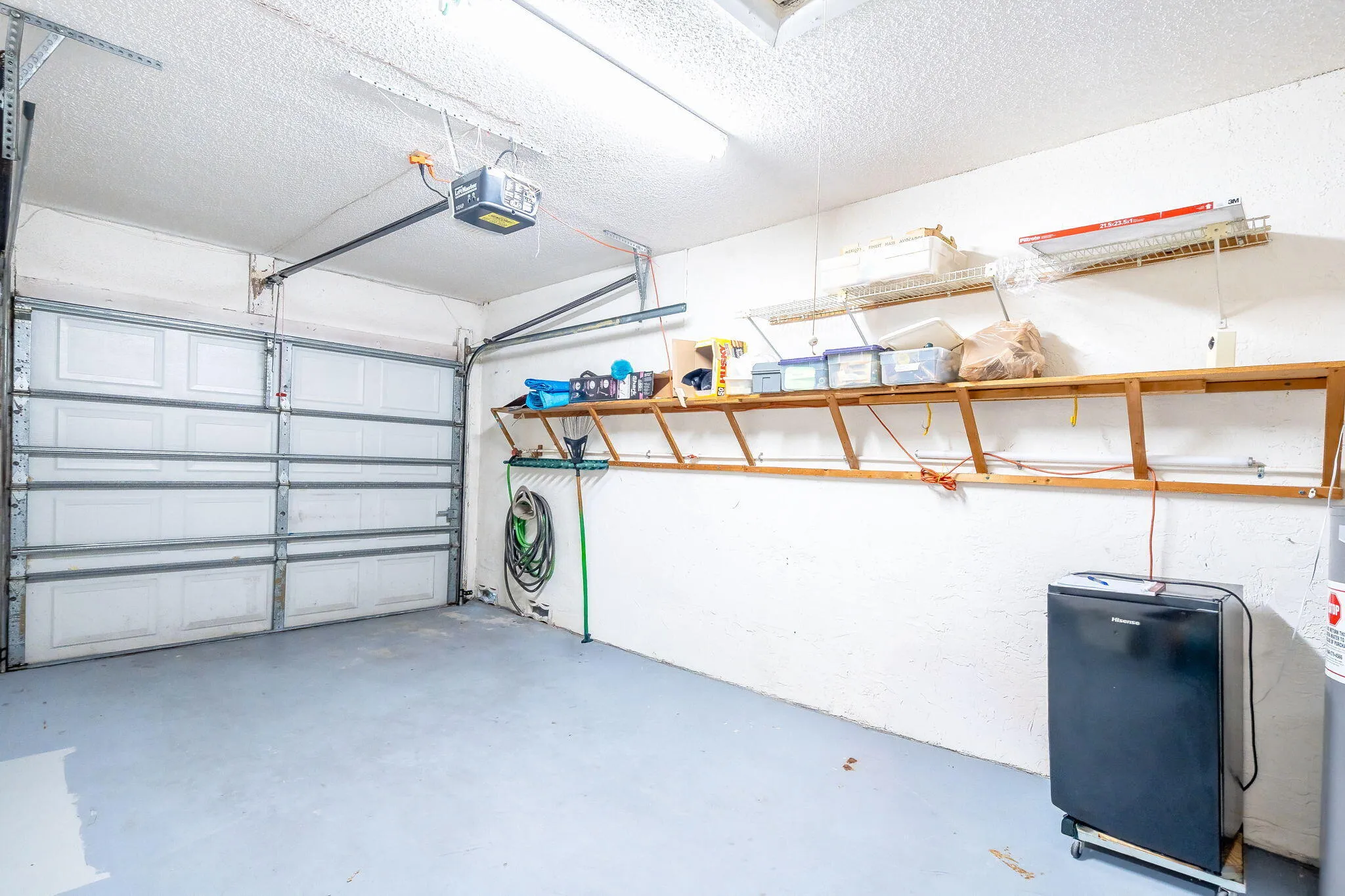 Garage space featuring an overhead door and built-in shelving