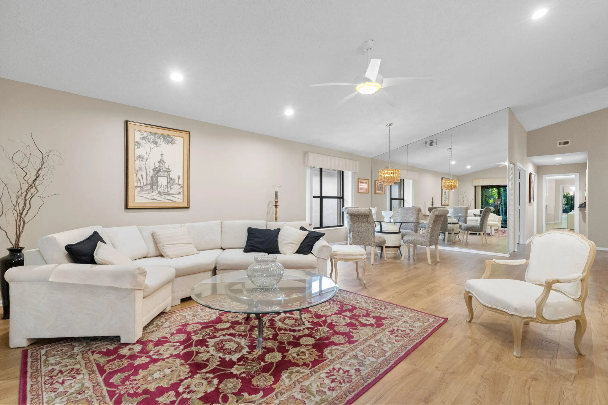 Wood-finish flooring throughout, recessed lighting, vaulted ceilings, and a mirrored accent wall