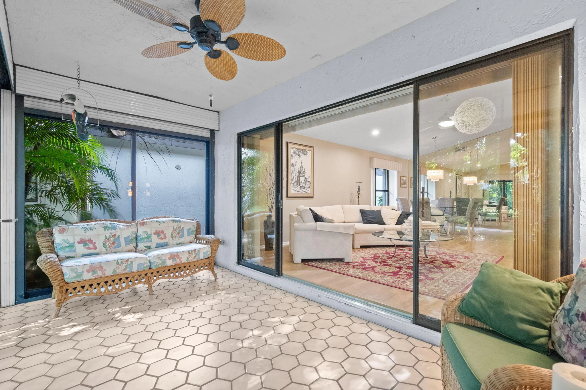 Hexagonal tile flooring, ceiling fan, and large glass sliding doors