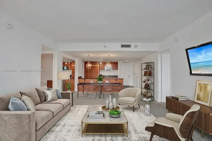 Open-concept living space featuring wood-finish cabinetry, recessed lighting, and a neutral color palette virtually staged