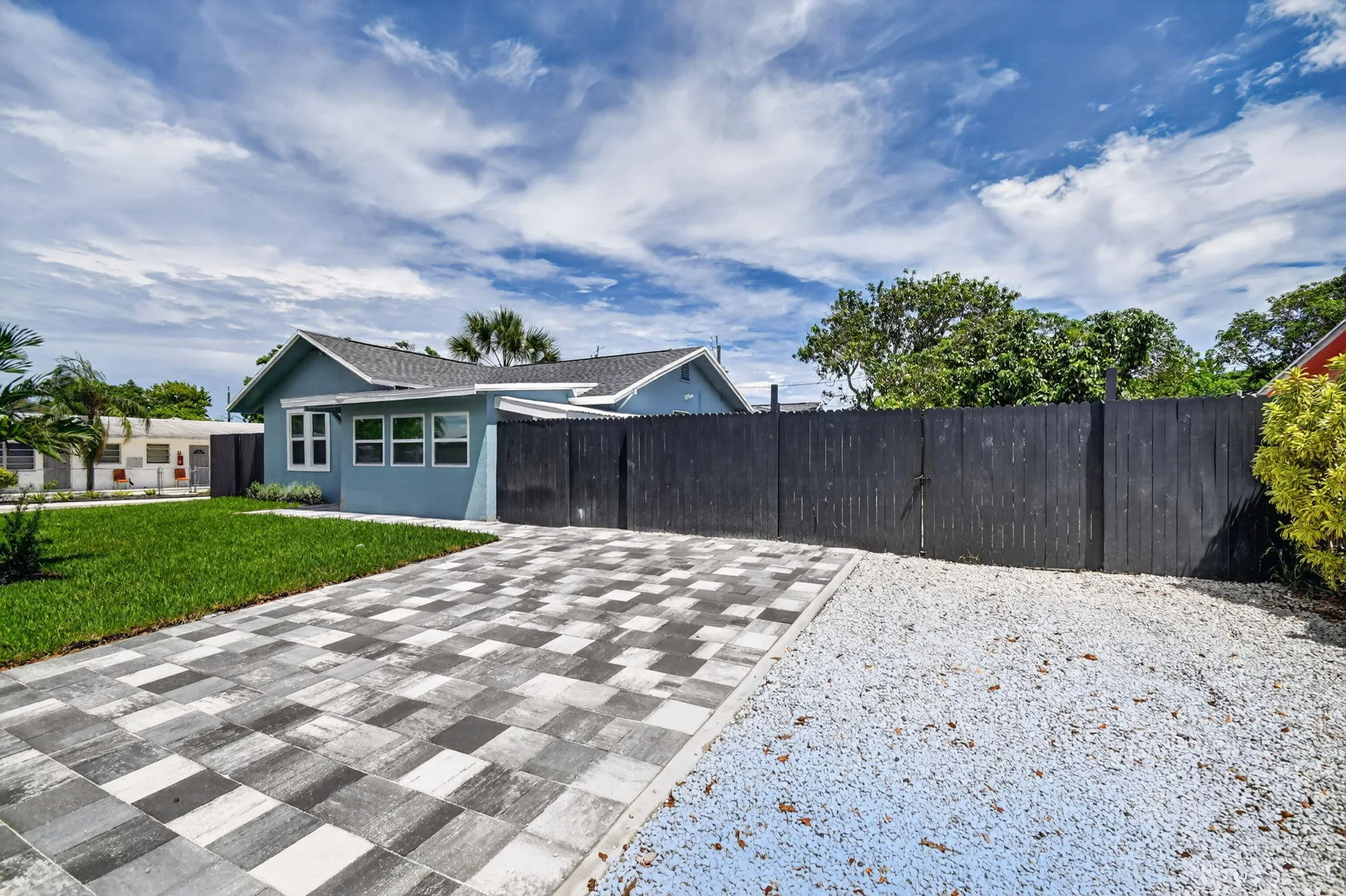 Exterior featuring a blue facade, white trim, and a dark shingle roof