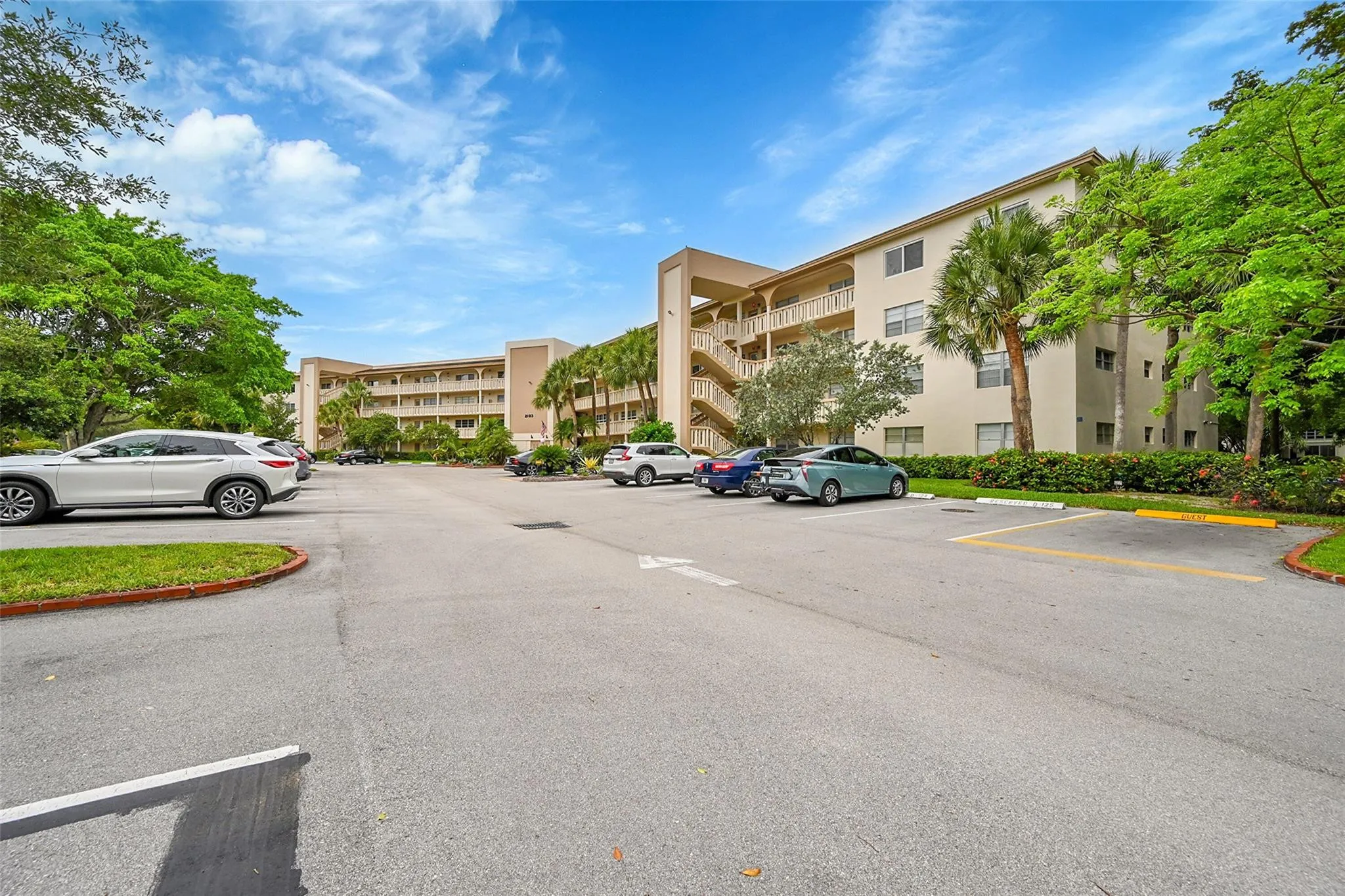 Multi-story building featuring stucco exterior, multiple balconies, and exterior staircases