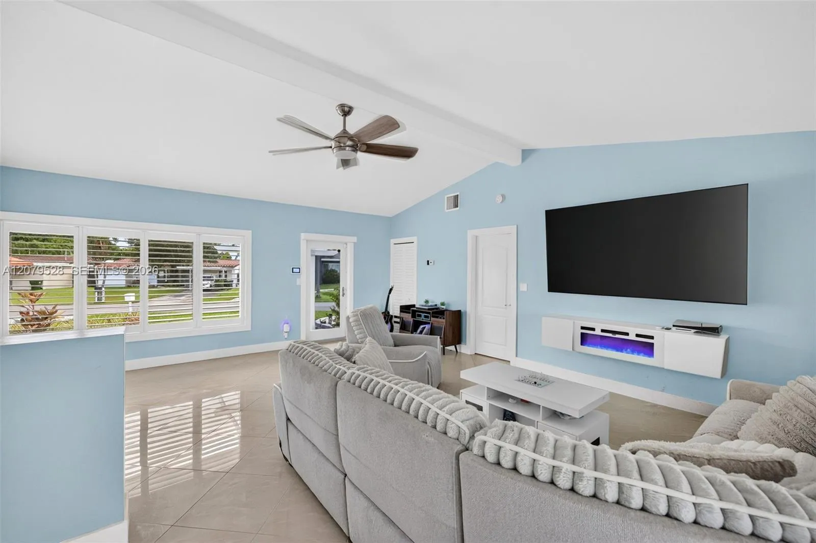 Living rm on main level. Primary bedroom to right. stairs up and down to the left. Volume beamed ceilings, impact windows, plantation shutters