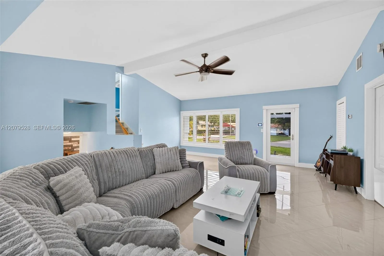 Living rm on main level. Primary bedroom to right. stairs up and down to the left. Volume beamed ceilings, impact windows, plantation shutters
