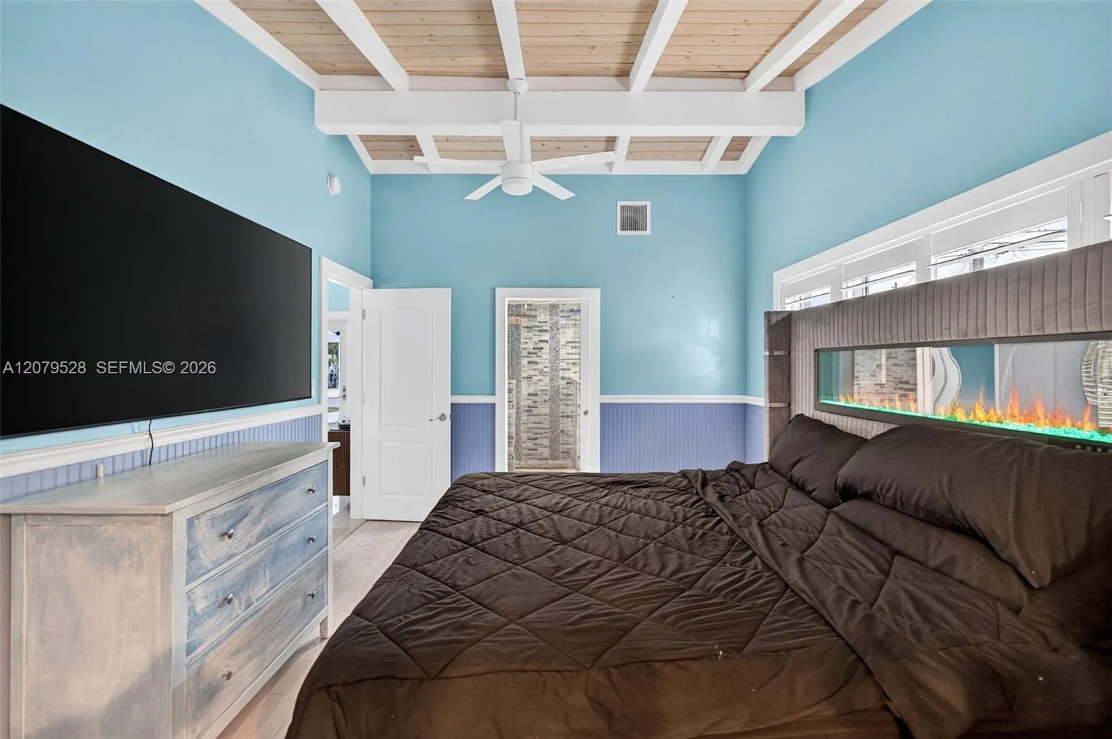 Oversized primary bedroom w/ beamed ceiling, Plantation Shutters and large walk in closet, en suite bathroom, on main level