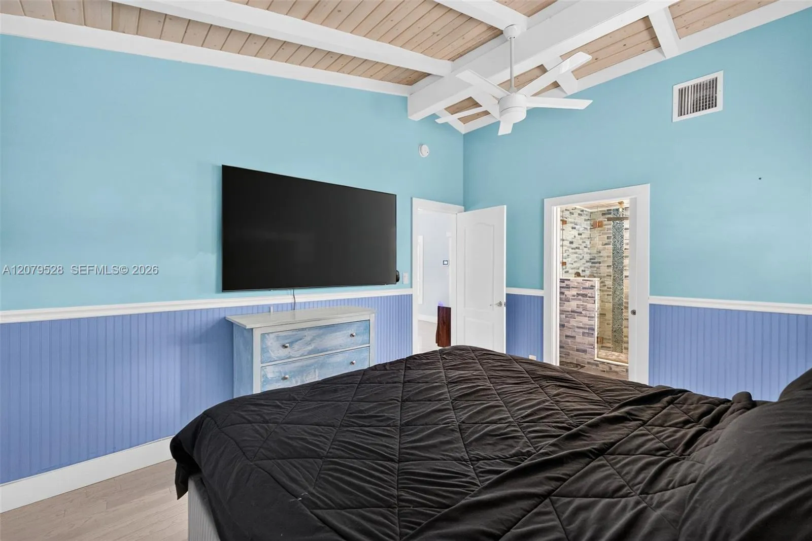 Oversized primary bedroom w/ beamed ceiling, Plantation Shutters and large walk in closet, en suite bathroom, on main level