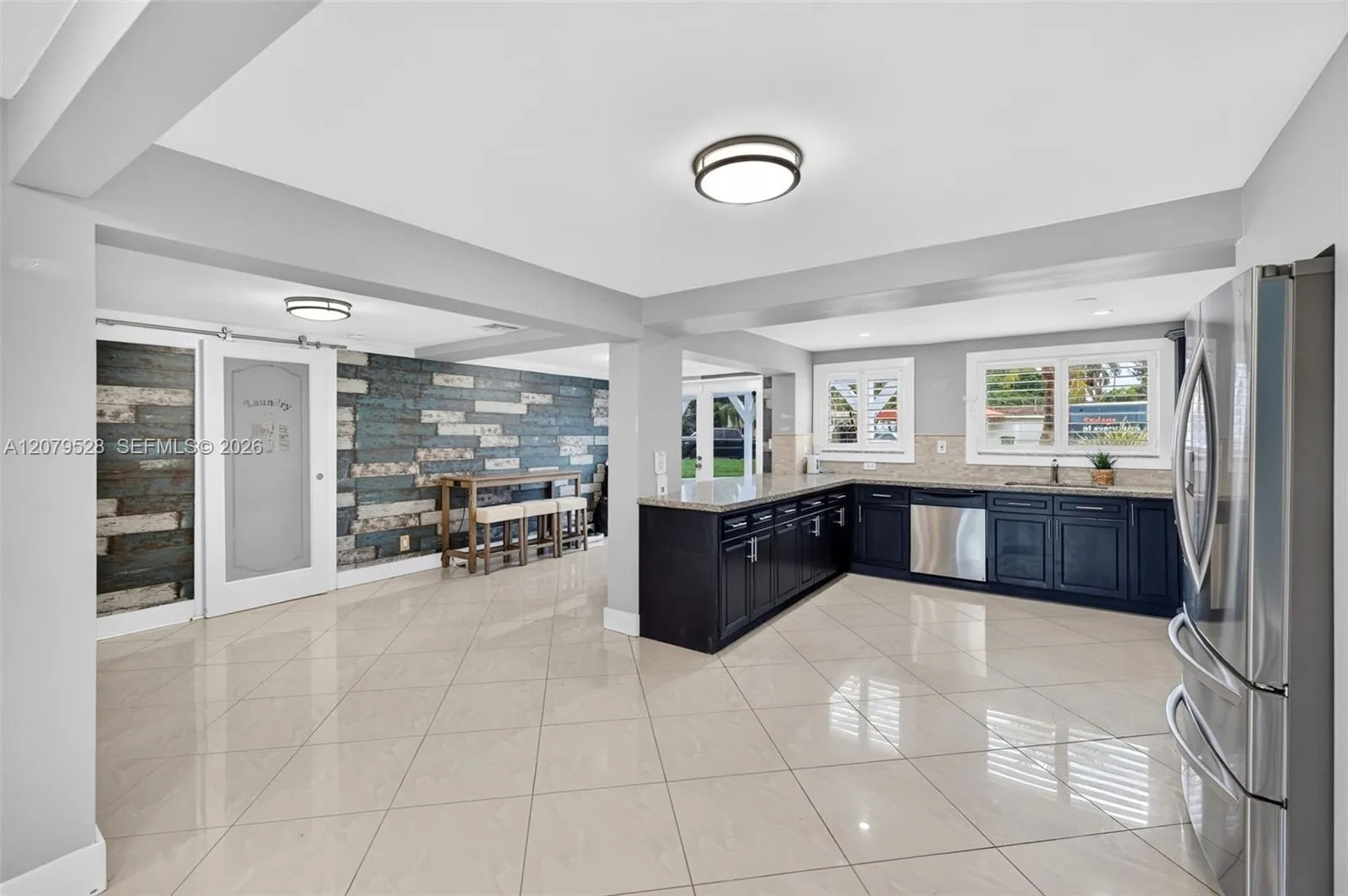 Large bright kitchen w/ windows everywhere, plantation shutters, wood cabinets, stainless appliances and granite counters