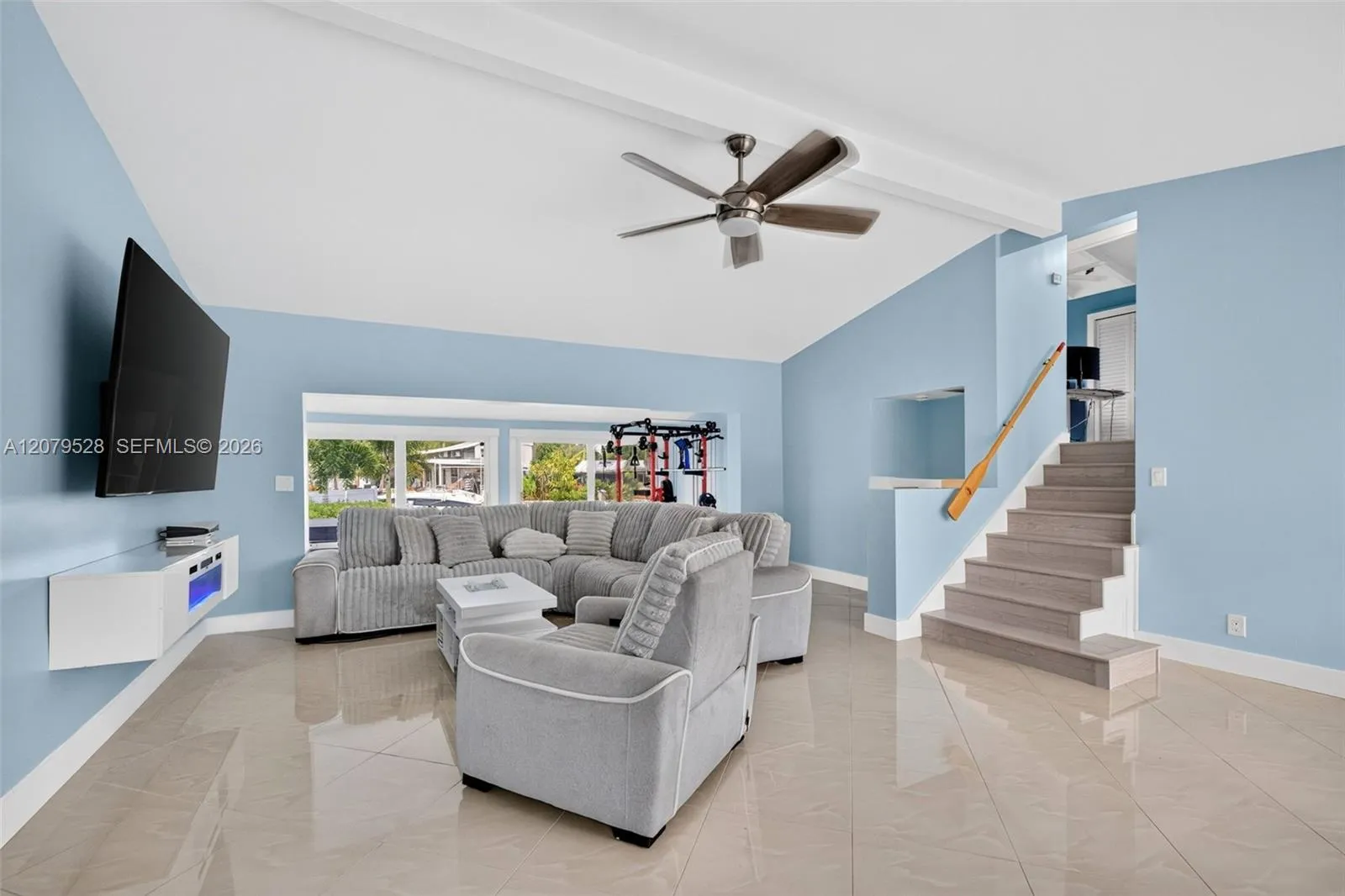 Living rm on main level. Primary bedroom to left. stairs up and down to the right. Volume beamed ceilings, impact windows, plantation shutters