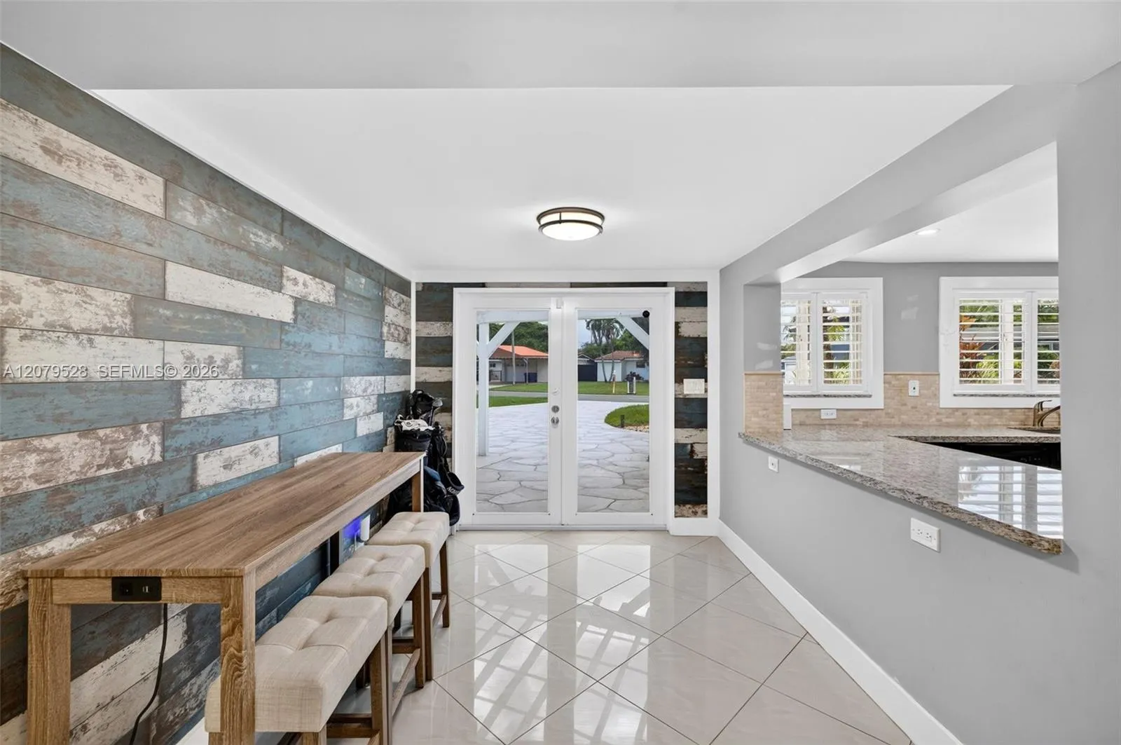 Great room or Dining Room downstairs, off kitchen, beyond this space are doors to front of house. Come right in here w/ your groceries. Beachy paneled walls