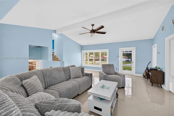 Living rm on main level. Primary bedroom to right. stairs up and down to the left. Volume beamed ceilings, impact windows, plantation shutters