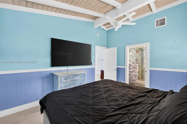 Oversized primary bedroom w/ beamed ceiling, Plantation Shutters and large walk in closet, en suite bathroom, on main level