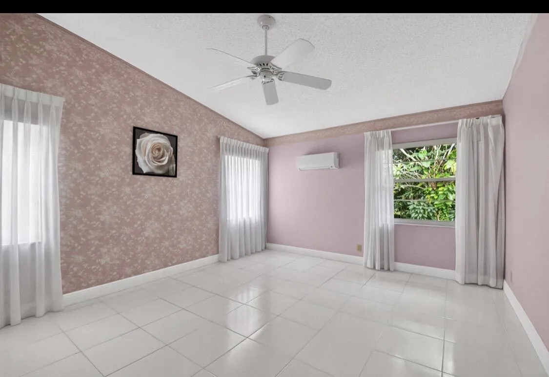 Spacious primary bedroom with vaulted ceilings and abundant natural light.