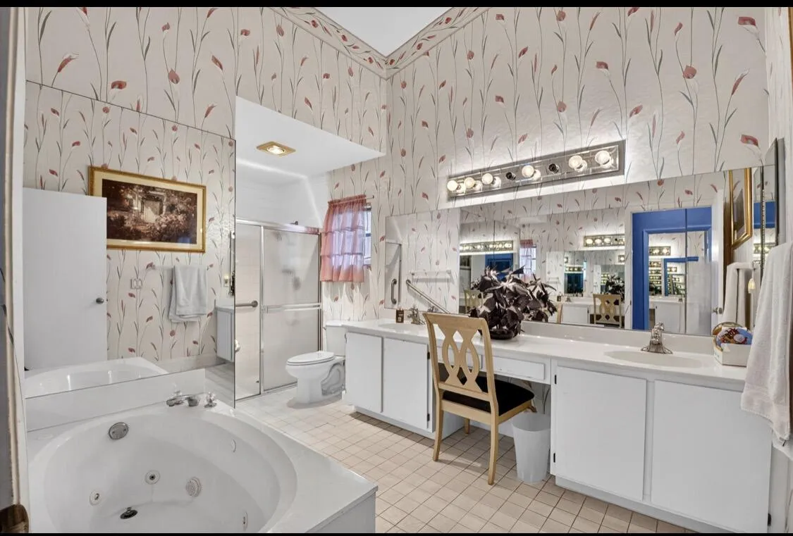 Spacious primary bath with dual vanities and soaking tub.