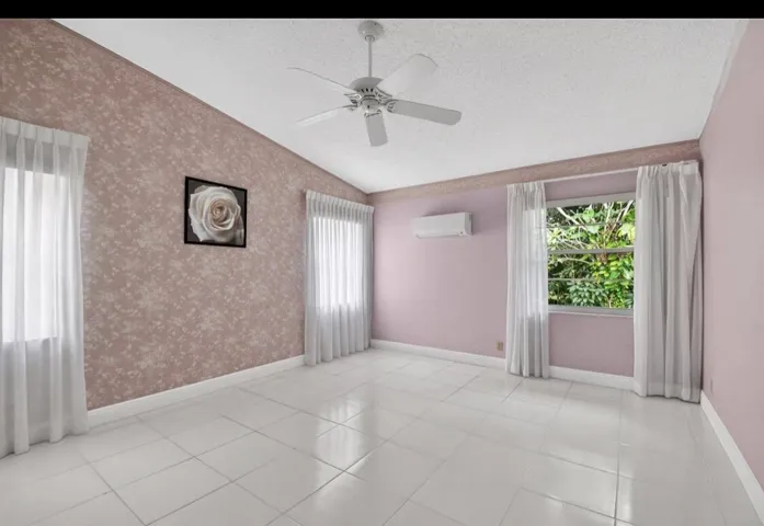 Spacious primary bedroom with vaulted ceilings and abundant natural light.